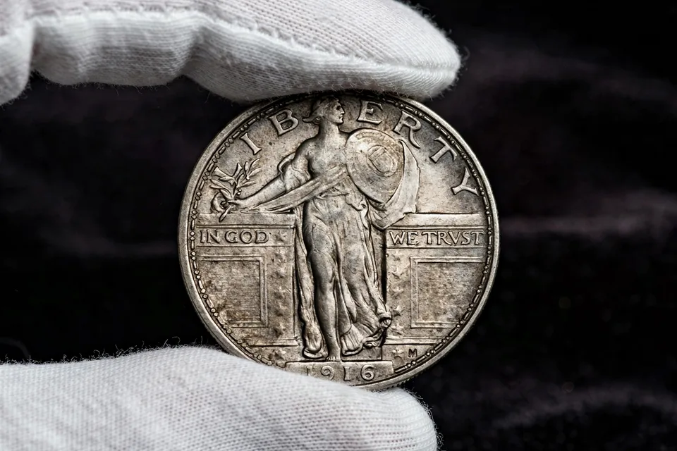 1916 Standing Liberty quarter obverse held in cotton gloves — the $207,400 first-year rarity with only 52,000 minted
