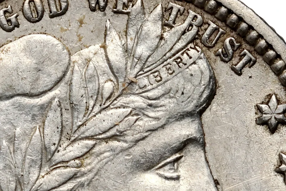 Barber dime obverse close-up — the LIBERTY lettering in the headband above Liberty's forehead, the key grading check