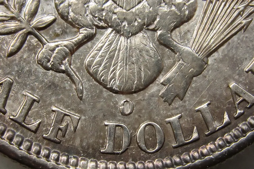 how much is a Barber half dollar worth — extreme macro of the tiny O mint mark below the eagle’s tail feathers above the D in DOLLAR on an 1892-O Barber half dollar