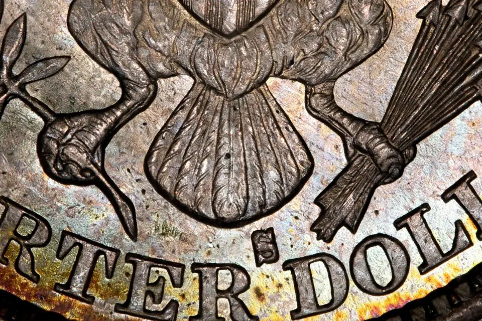 how much is a Barber quarter worth — extreme macro of the small S mint mark below the eagle's tail feathers on a 1901-S Barber quarter