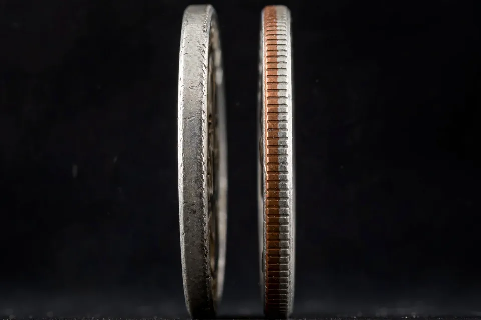 silver quarter edge test — magnified reeded edges showing a solid silver edge beside a copper-striped clad edge